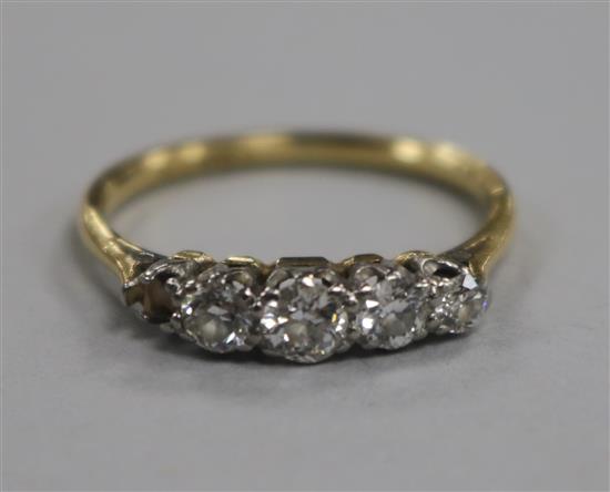 An 18ct gold and platinum, four (ex 5) stone diamond half hoop ring, size P/Q.
